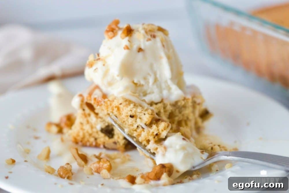 Homemade Applebees Blondies 2 A slice of homemade blondie with a fork on the side on a white round plate, showcasing its soft texture and golden brown edges.