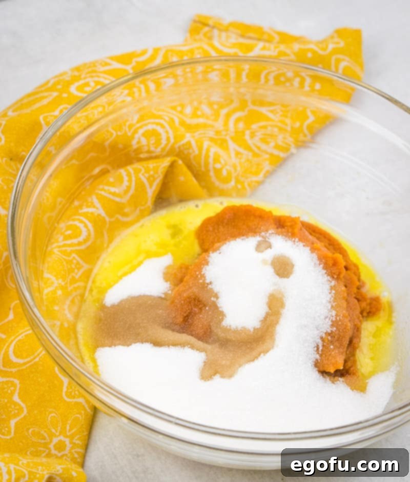 Mixing sugar, egg, pumpkin puree, and vanilla extract for pumpkin pull-apart bread filling