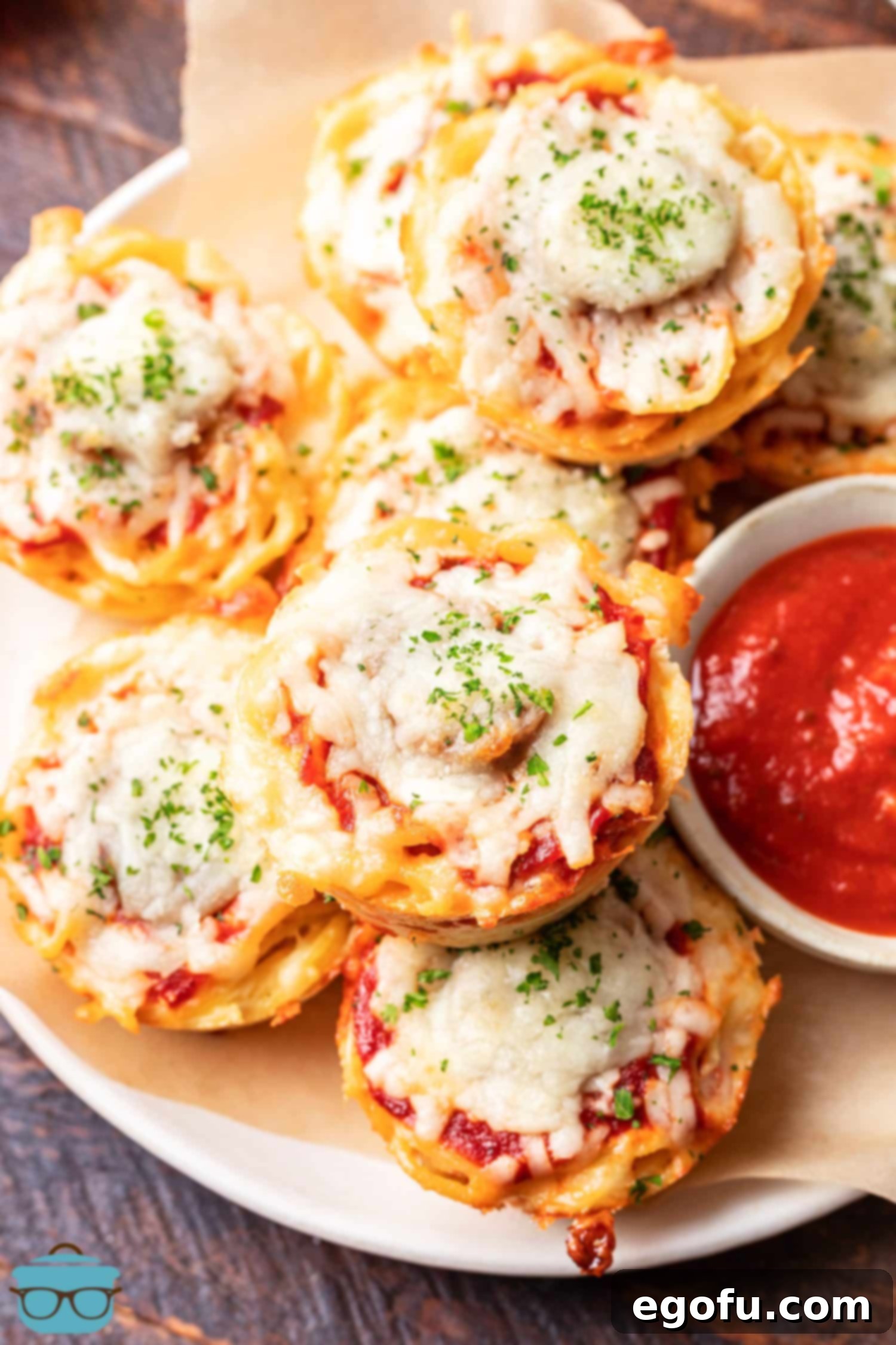 A small bowl of marinara and some Spaghetti Muffins.