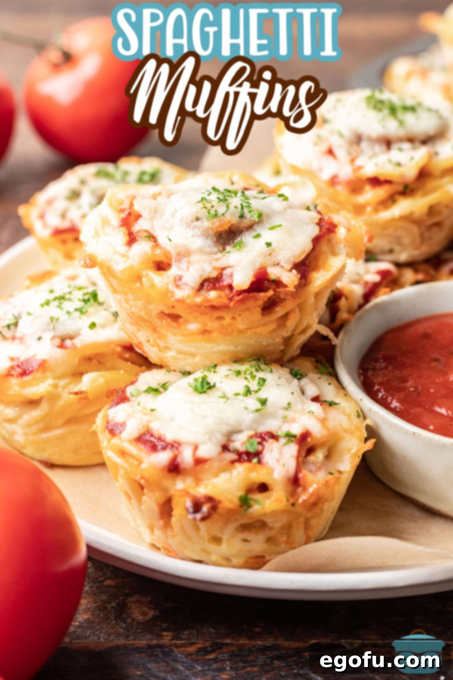 A few Spaghetti Muffins on a plate next to a bowl of sauce.