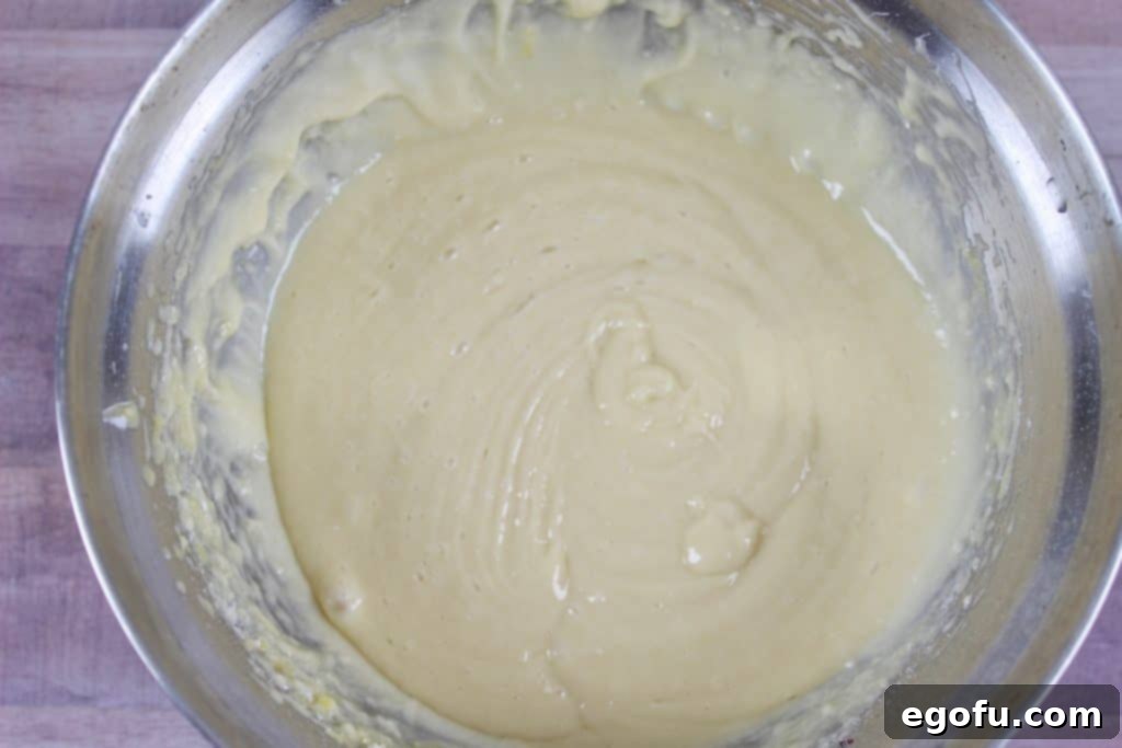 Close-up of a smooth cake mix batter in a mixing bowl, ready to be poured.