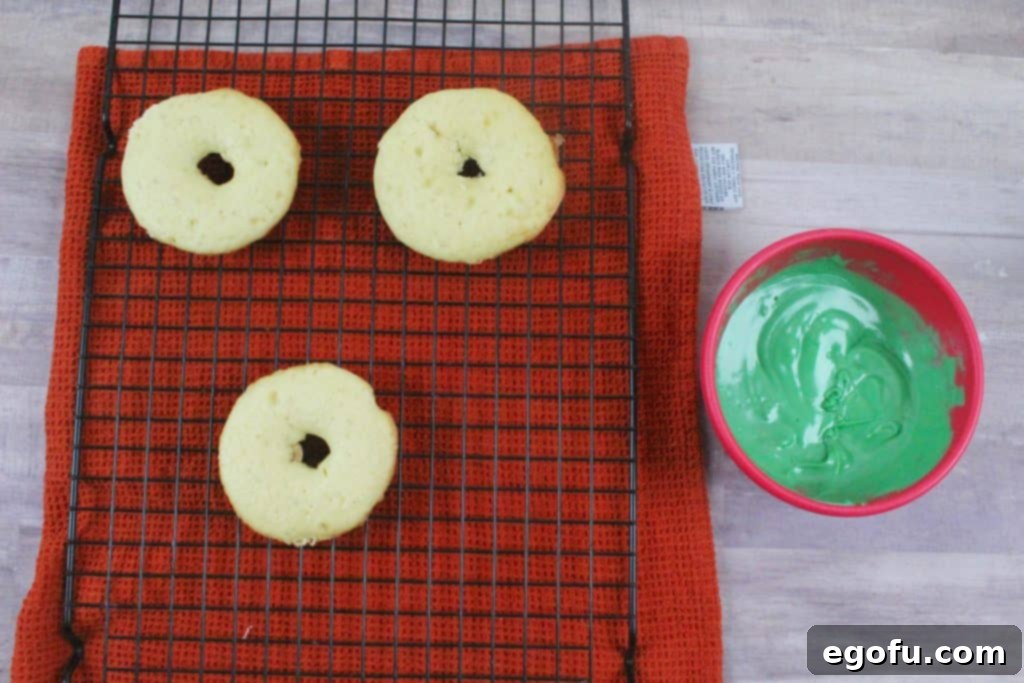 Freshly baked doughnuts on a cooling rack, golden brown and perfectly shaped.