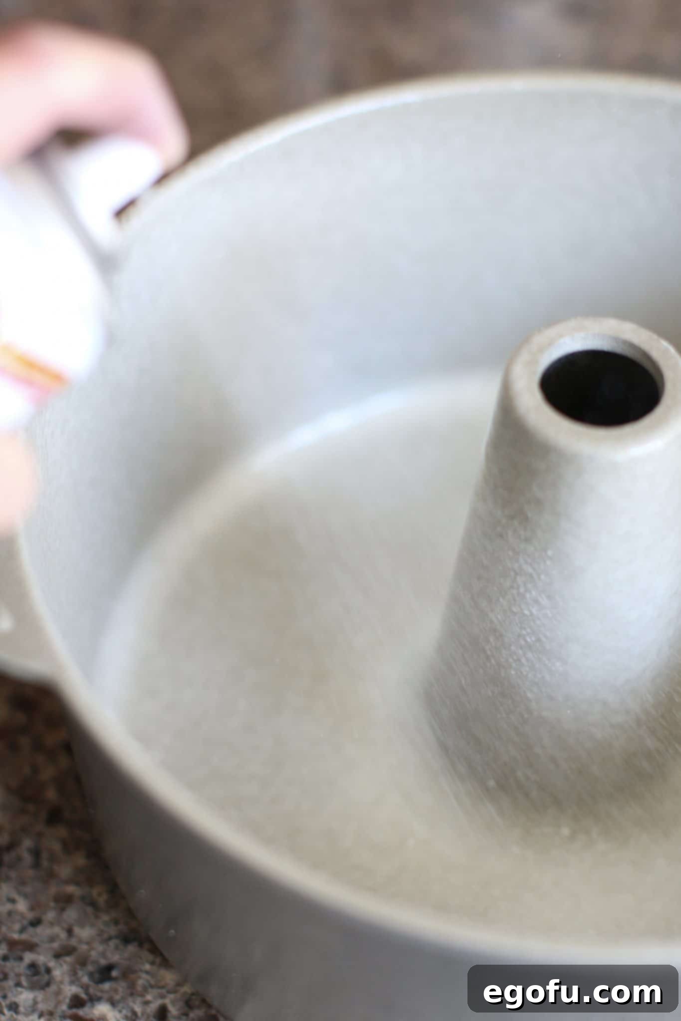 Baker's Joy flour nonstick cooking spray being sprayed into tube pan.