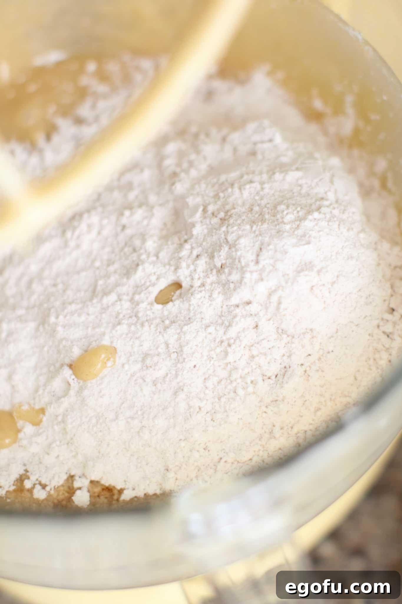 adding all-purpose flour into mixing bowl.