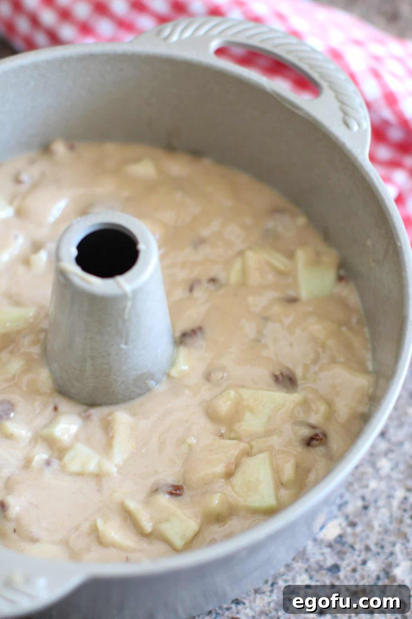 uncooked batter for fresh apple cake shown in a tube pan.
