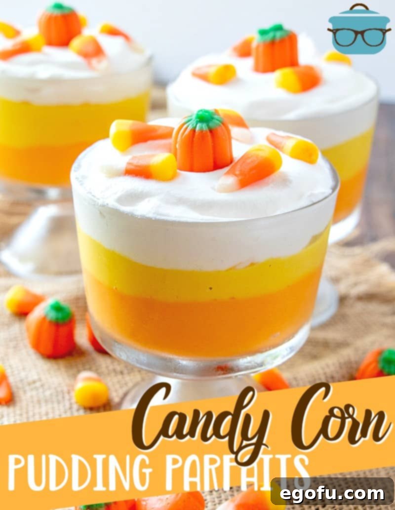 A close-up view of an inviting Easy Candy Corn Vanilla Pudding Parfait, showcasing its perfectly layered orange and yellow vanilla pudding, crowned with a generous swirl of whipped cream and garnished with festive candy pumpkins and classic candy corn pieces.