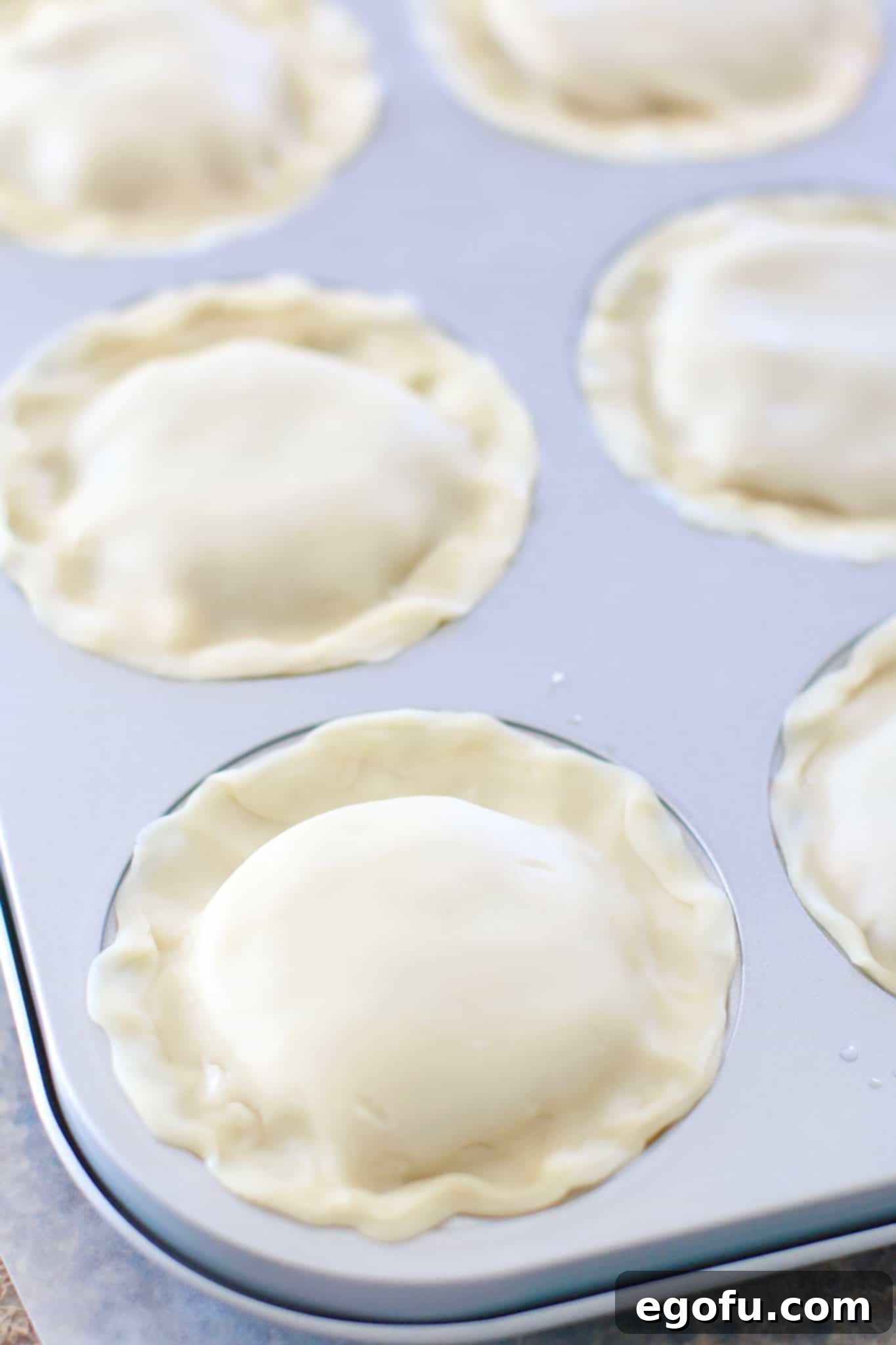 Cherry Cheesecake Minis 14 The edges of the mini pie crusts beautifully crimped and sealed, creating a decorative and secure border.