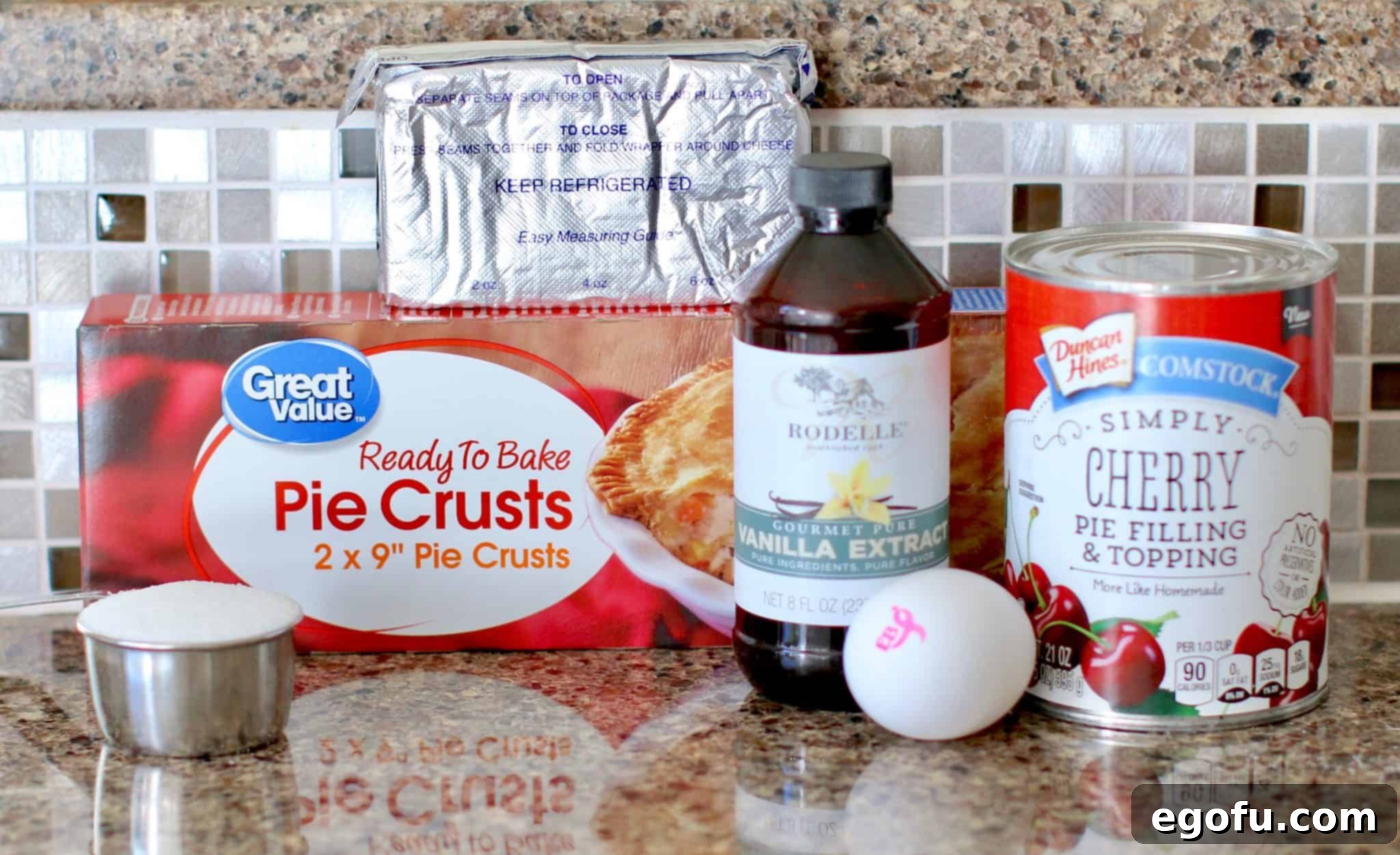 Cherry Cheesecake Minis 4 Key ingredients laid out: a box of refrigerated pie crusts, a can of cherry pie filling, a block of cream cheese, and a bowl of cheesecake filling.