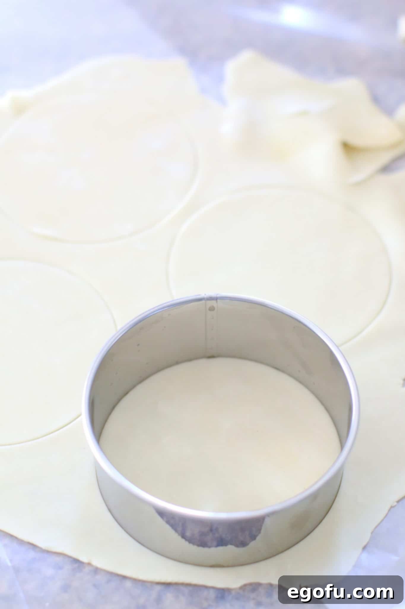 Cherry Cheesecake Minis 8 A smaller Pampered Chef pie crust cutter meticulously shaping additional round crusts from the remaining refrigerated dough, intended for the pie tops.