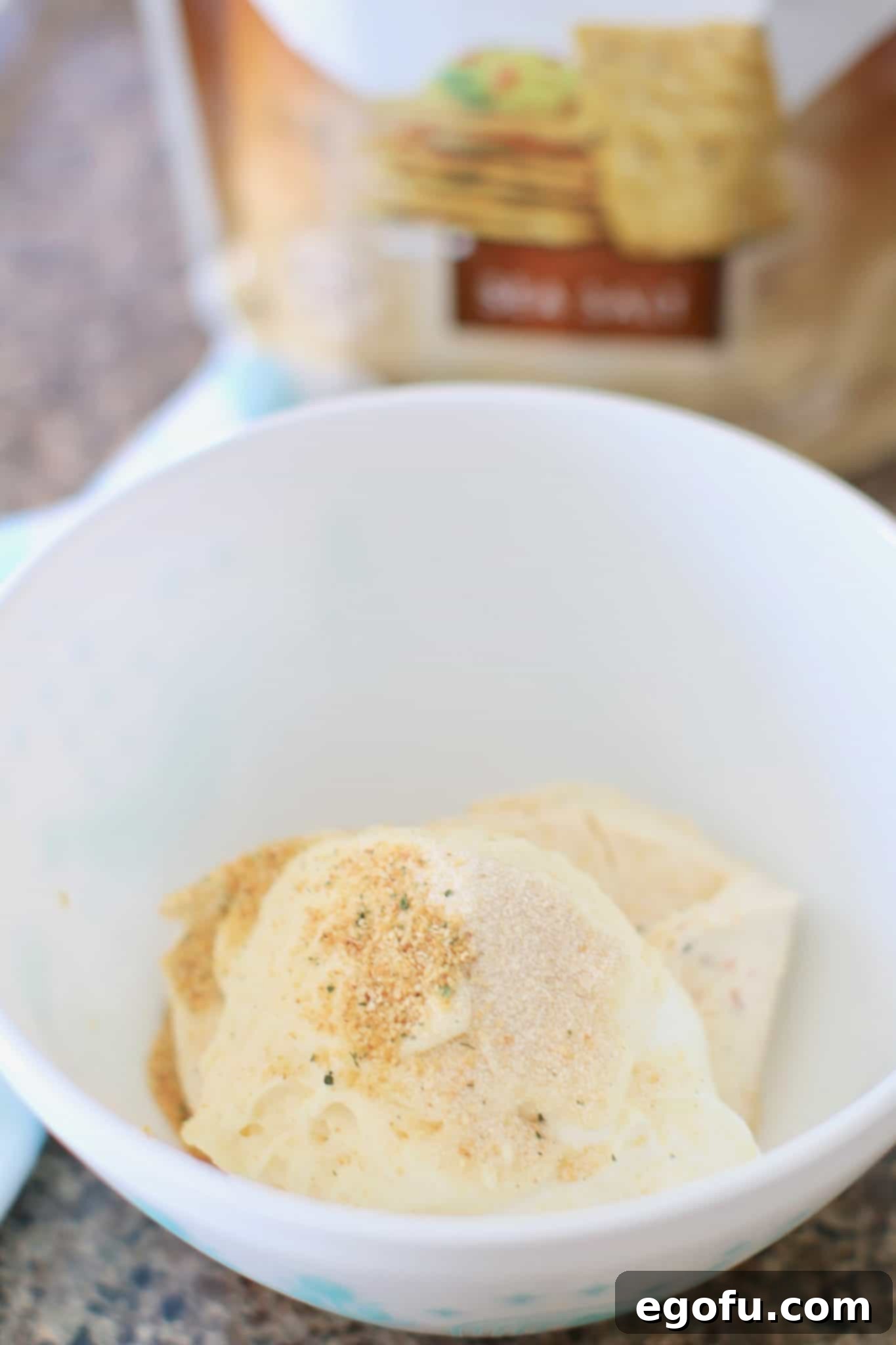 vegetable cream cheese, sour cream mayonnaise, onion powder, garlic powder in a white bowl.
