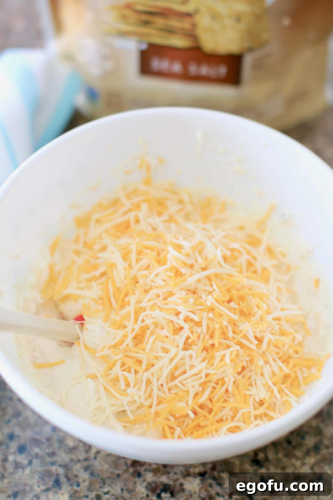 shredded cheese with cream cheese mixture in a bowl.