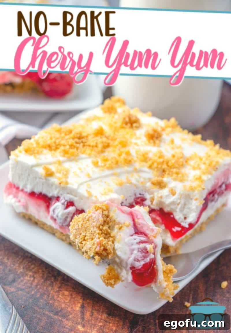 A close-up view of the No-Bake Cherry Yum Yum layered dessert with a fork removing a perfect piece, showcasing its distinct layers.