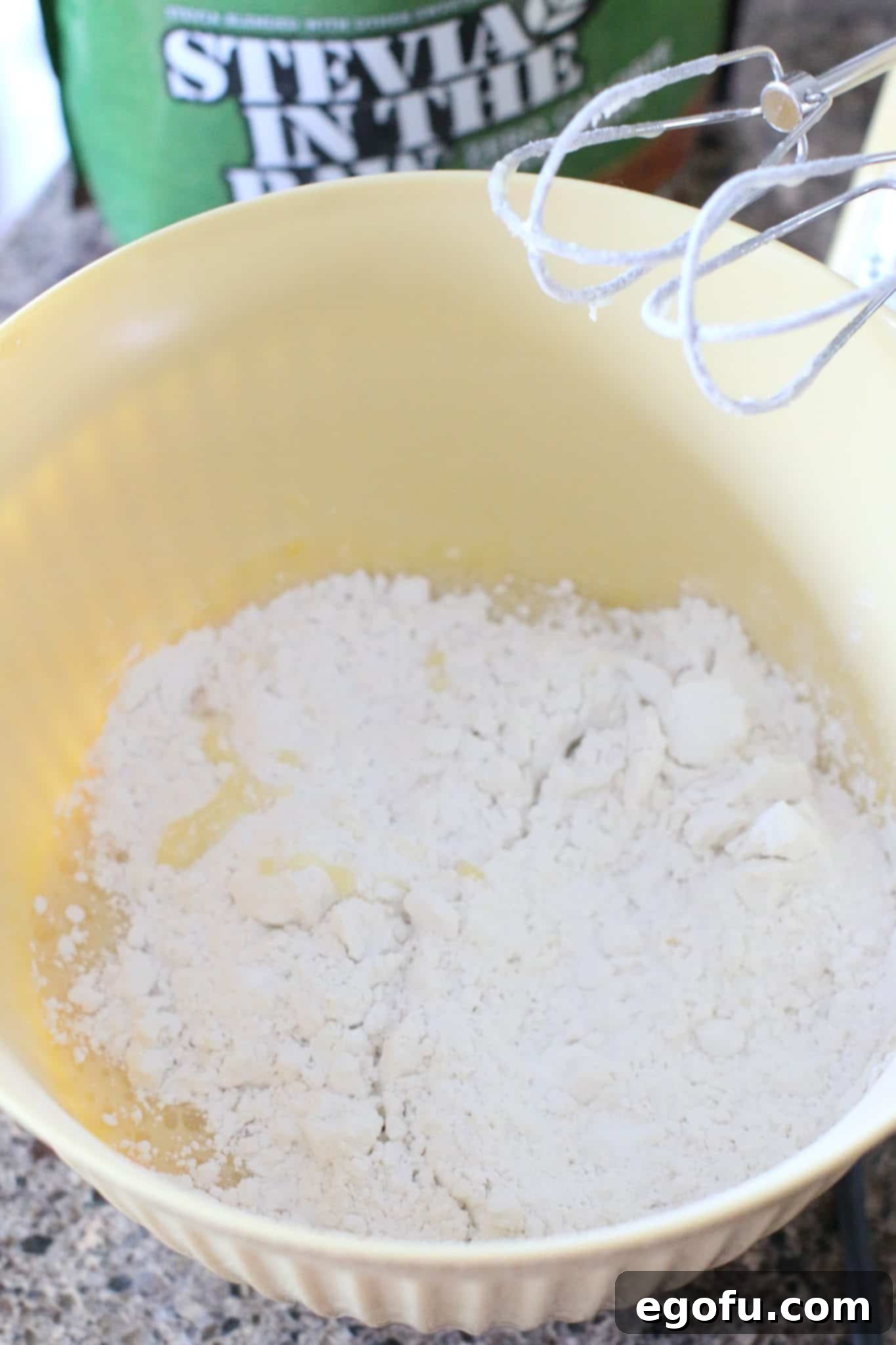 All-purpose flour, baking powder, and salt added to the wet ingredients in a bowl.