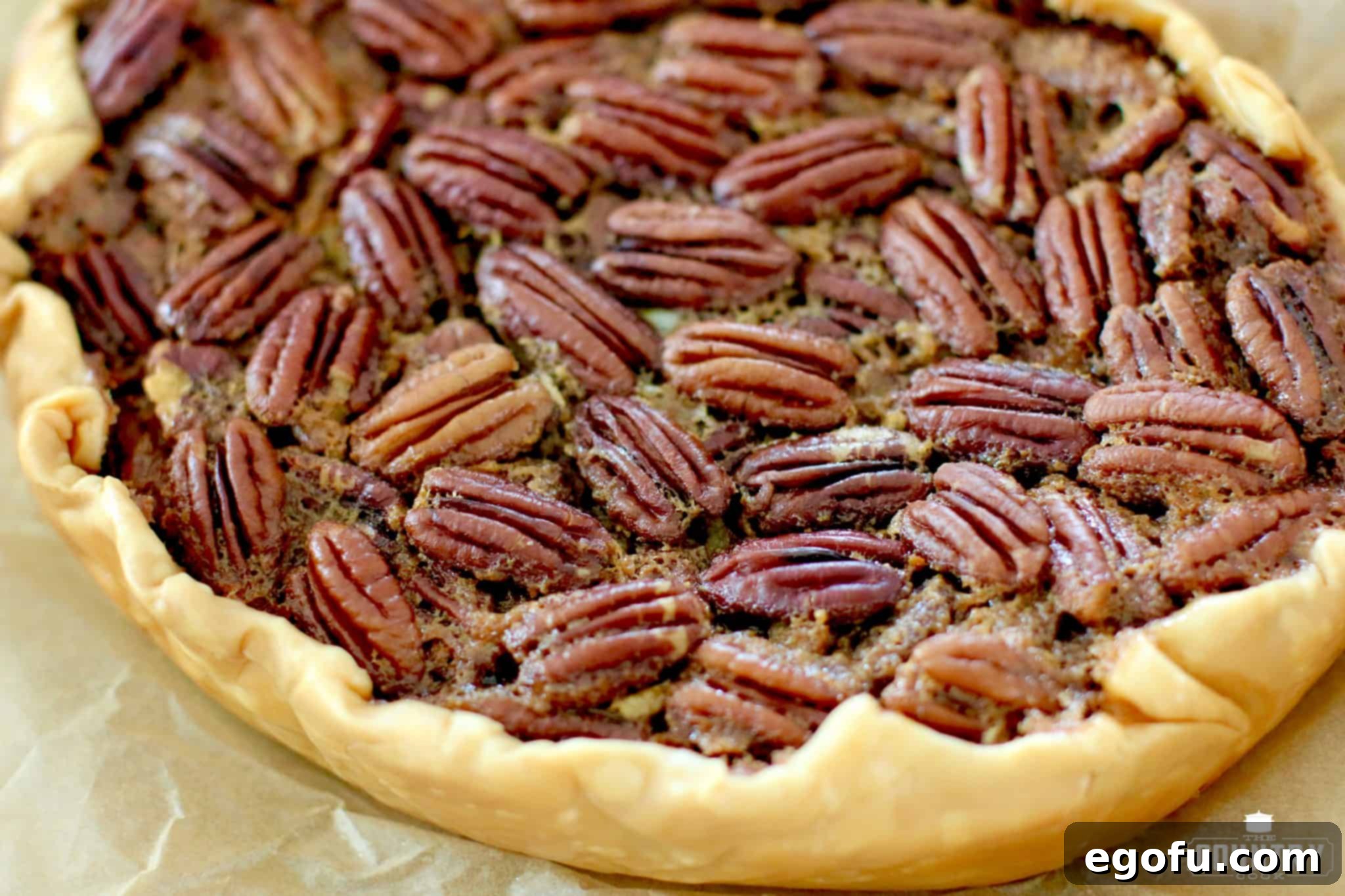Delicious slow cooker pecan pie slice on a white plate, garnished with whipped cream and a sprinkle of cinnamon, showcasing its rich, gooey filling and golden-brown crust.