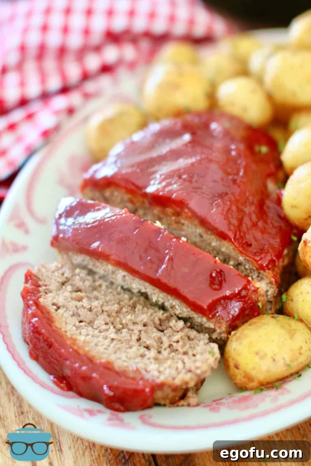 Sliced meatloaf and baby gold potatoes on an oval plate, showcasing a complete and comforting meal.