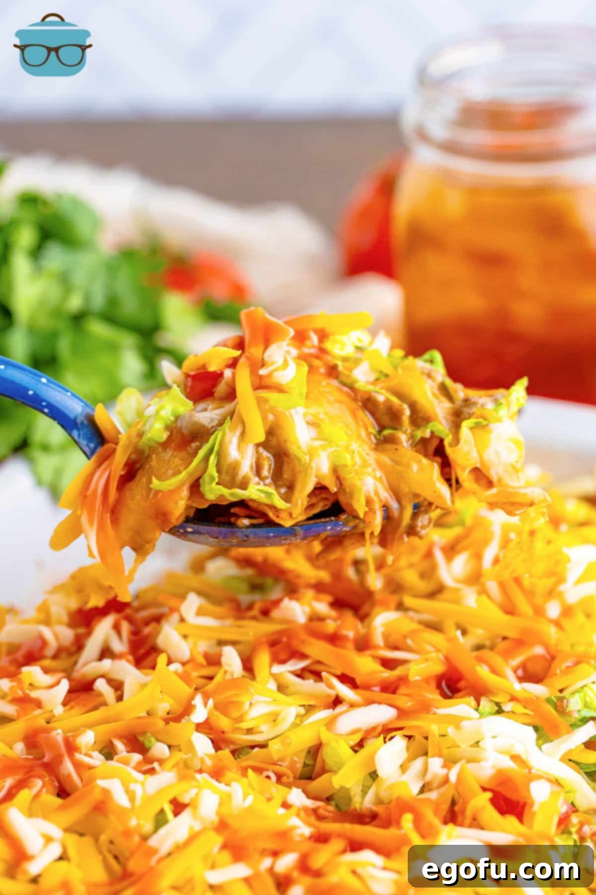 A serving utensil holding a scoop of Dorito Taco Casserole.