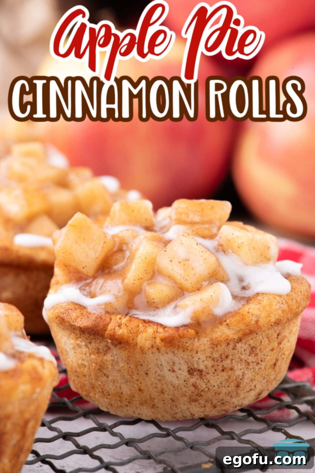 Several Apple Pie Cinnamon Rolls resting on a cooling rack, drizzled with sweet white glaze, ready to be enjoyed.