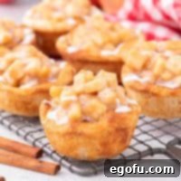 Close up looking at a few Apple Pie Cinnamon Rolls, showcasing their rich apple filling and white glaze.