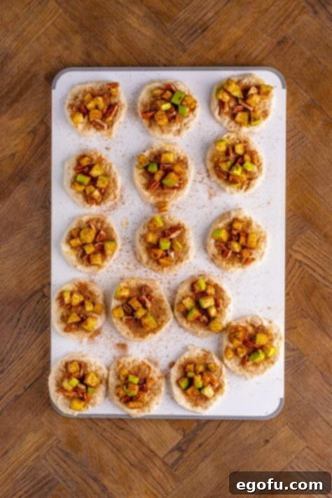 Diced apple mixture placed on individual biscuit slices.
