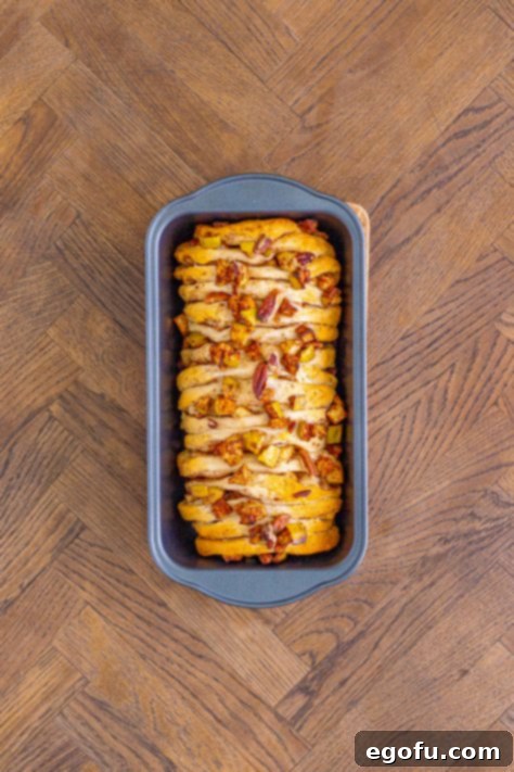A fully baked and golden-brown cinnamon apple bread just removed from the oven.