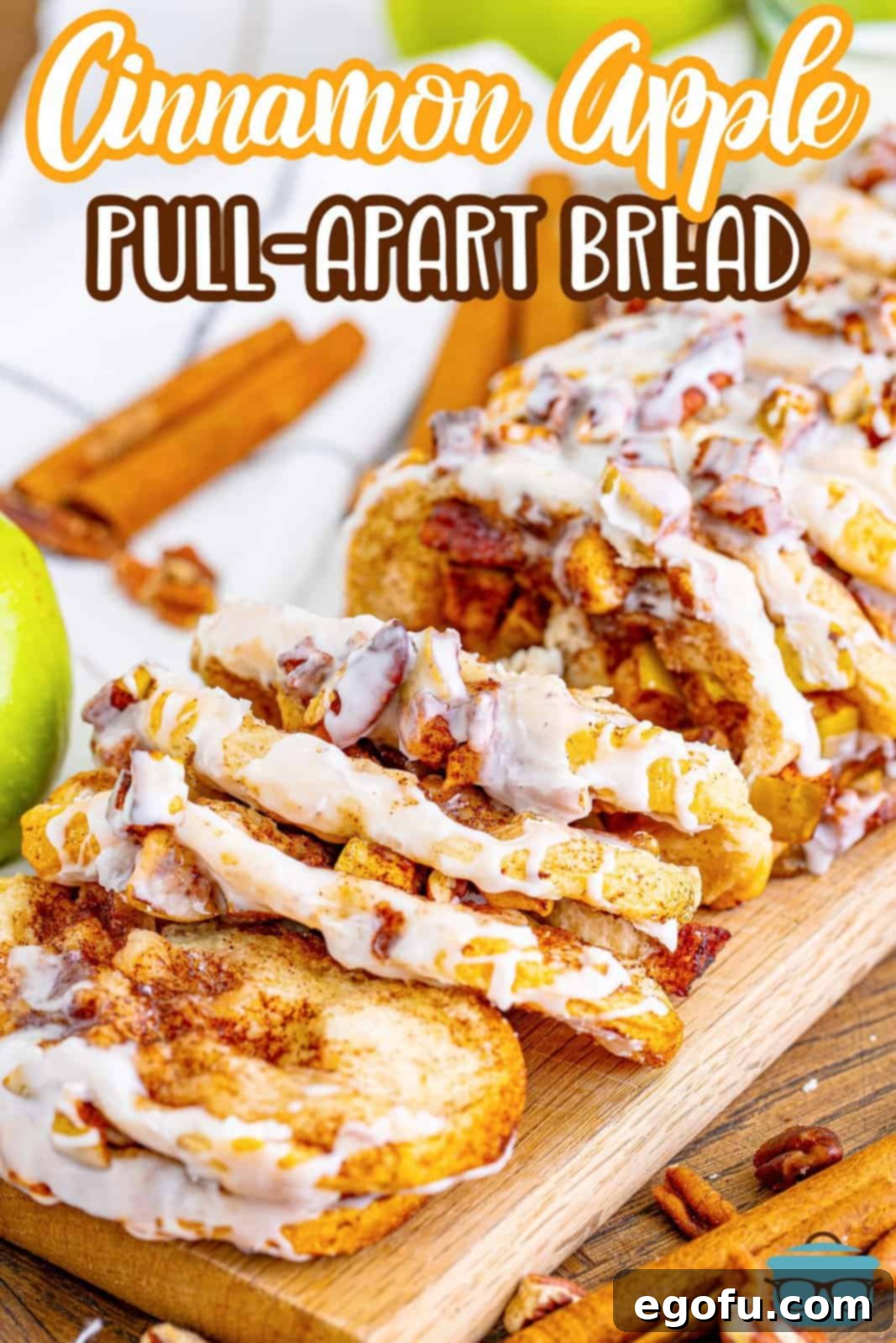 A close-up side view of baked Cinnamon Apple Pull-Apart Bread on a wooden board, with decorative cinnamon sticks in the blurred background, highlighting its inviting texture.