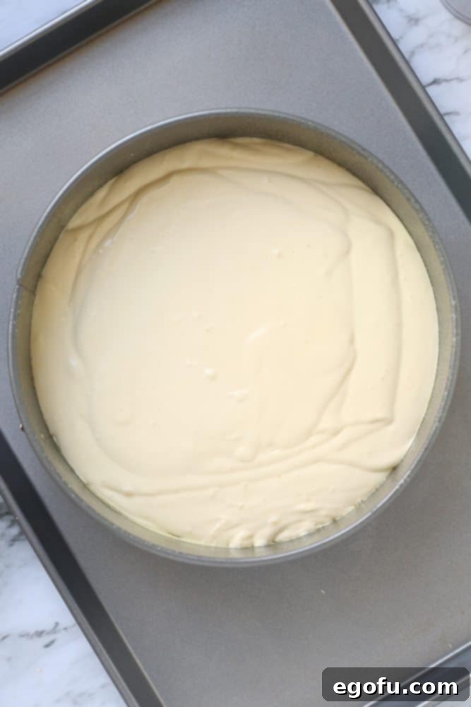 Unbaked low carb cheesecake filling poured into a springform pan, ready for the water bath.