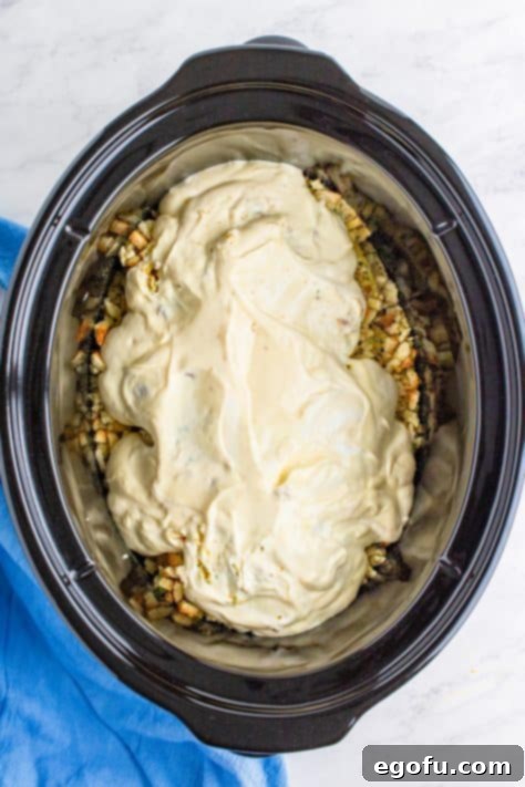 cream of chicken soup and sour cream spread on top of stuffing mixture in slow cooker.