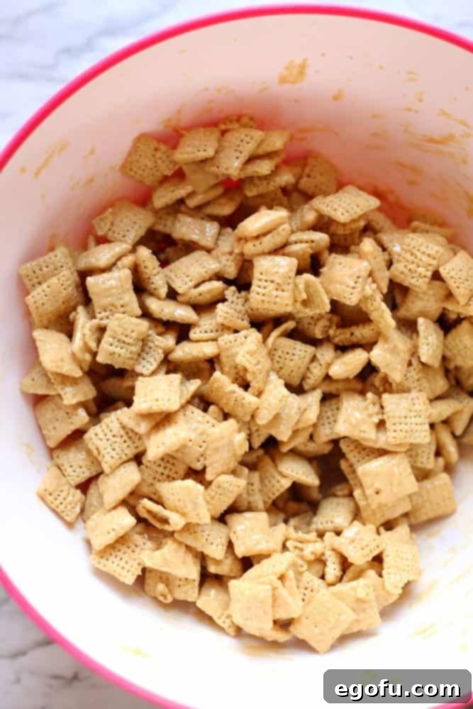 Chex, peanut butter, white chocolate chips in a bowl stirred together.