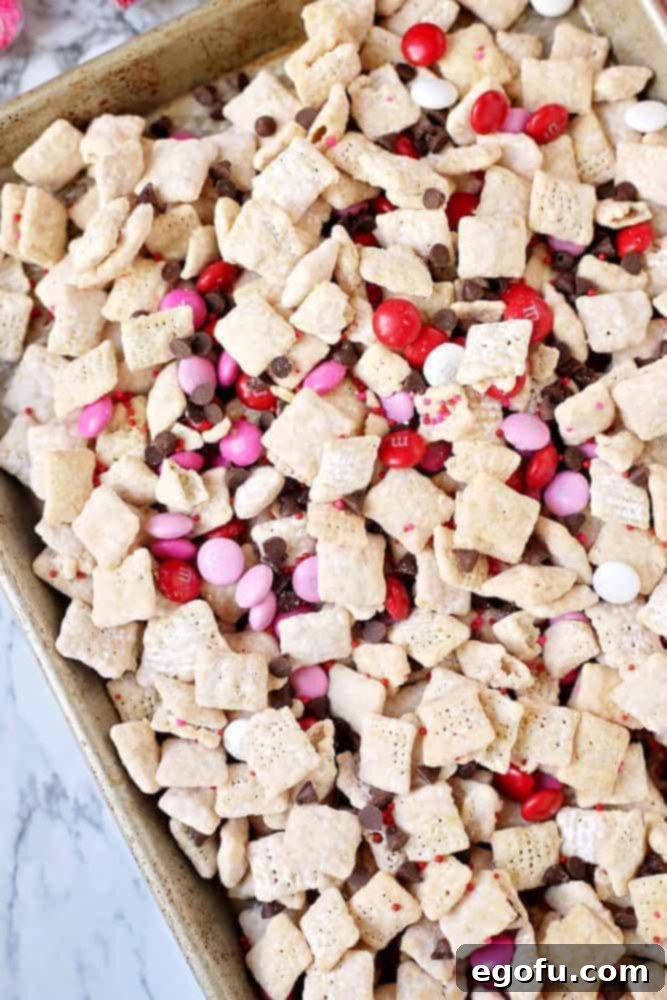 Muddy buddy snack mix cooling on a large baking tray.