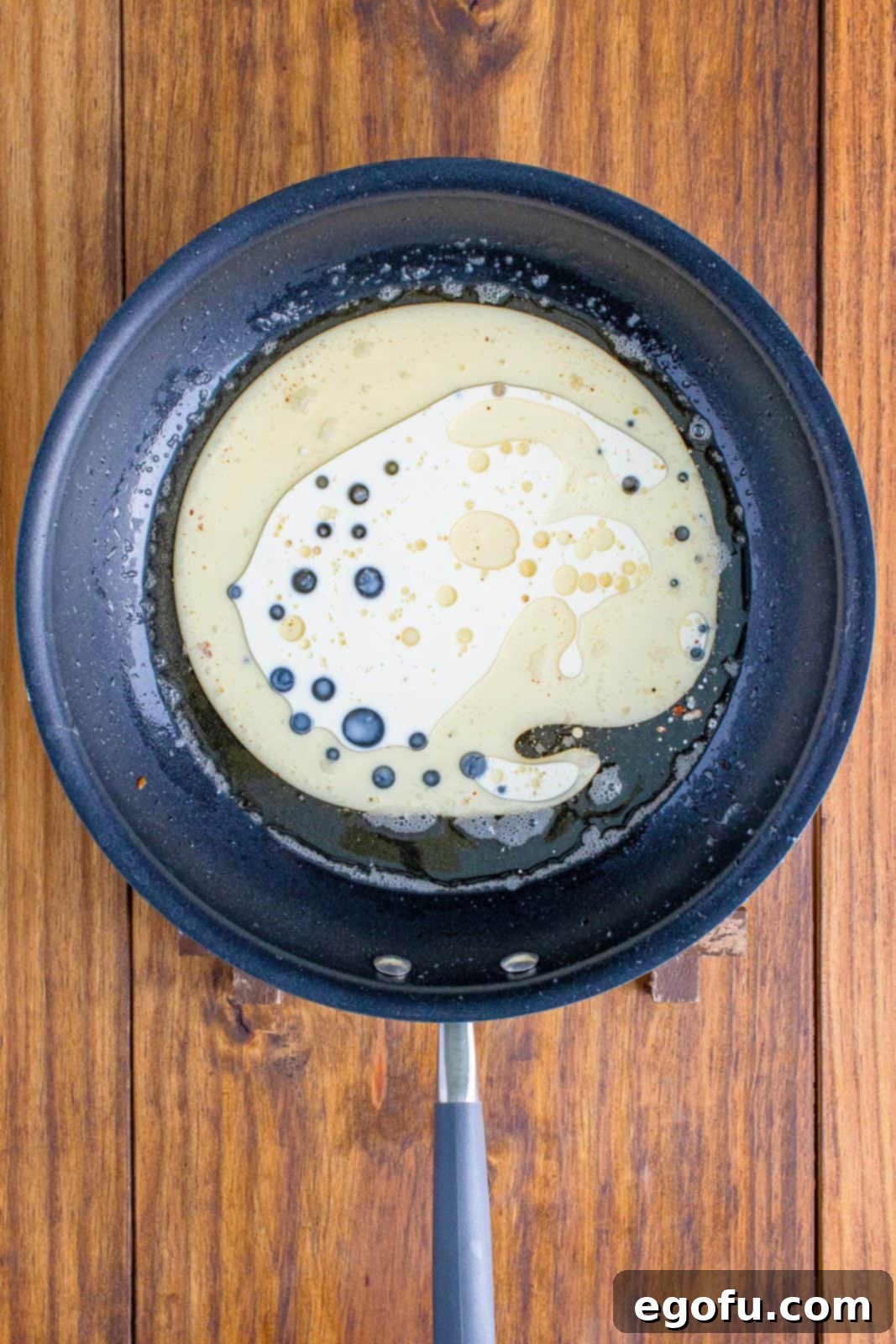 Reserved bacon fat gently melting in a saucepan over low heat.