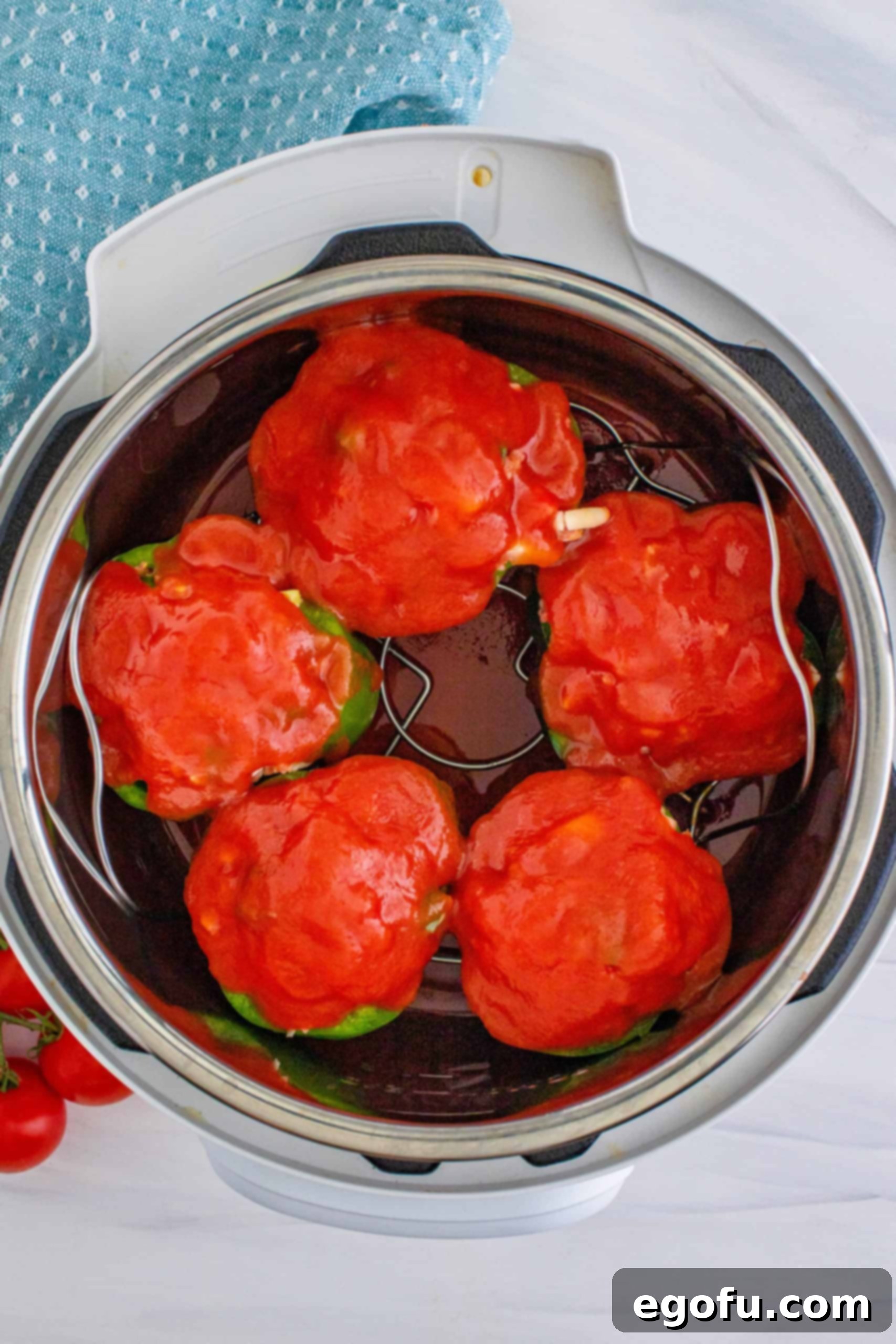 tomato sauce evenly spread on top of stuffed peppers.