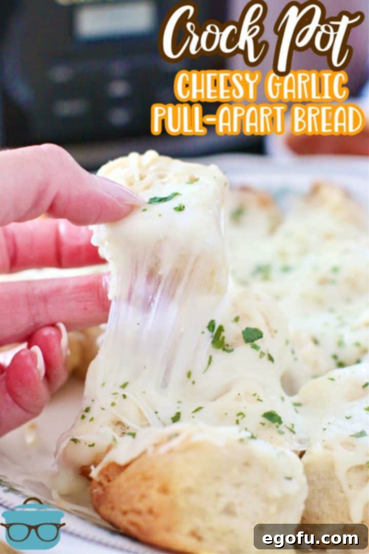 Close-up of a serving of Crock Pot Cheesy Garlic Pull Apart Bread on a plate, showing the melted cheese and a hand reaching for a piece.