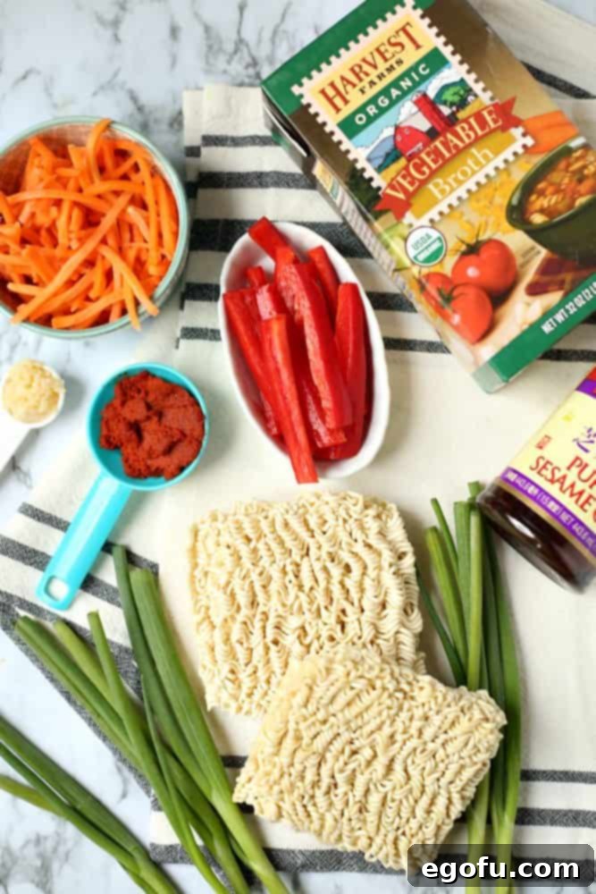 ramen noodles, green onions, sliced red pepper, julienned carrots, vegetable broth, red curry paste, minced garlic, sesame oil.