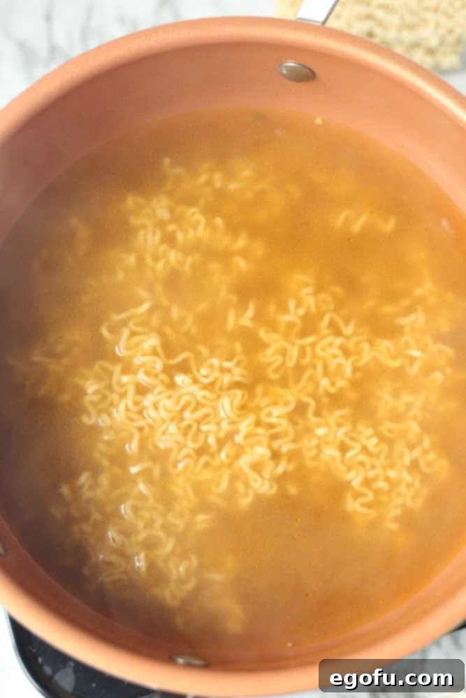 boiling ramen noodles in vegetable broth.