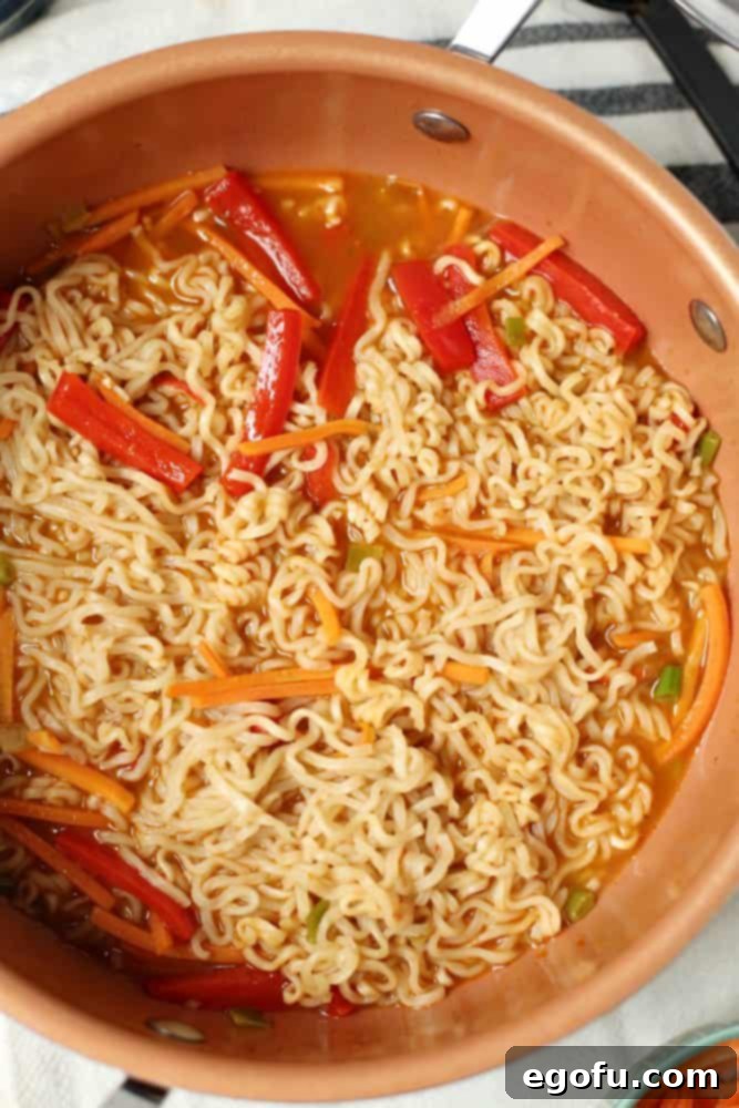 cooked vegetables added into pot with vegetable broth and ramen noodles.