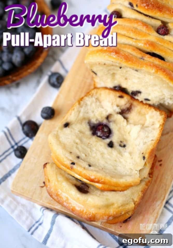 Heavenly Blueberry Tear & Share 3 Blueberry Pull Apart Bread, recipe from The Country Cook shown on a cutting board with some slices shown.