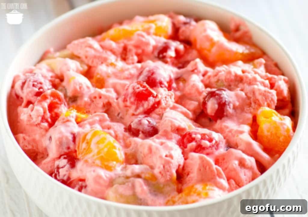 Cherry 7Up Fluff recipe made with cherry Jell-O, mandarin oranges, COOL WHIP, maraschino cherries, marshmallows and cream cheese