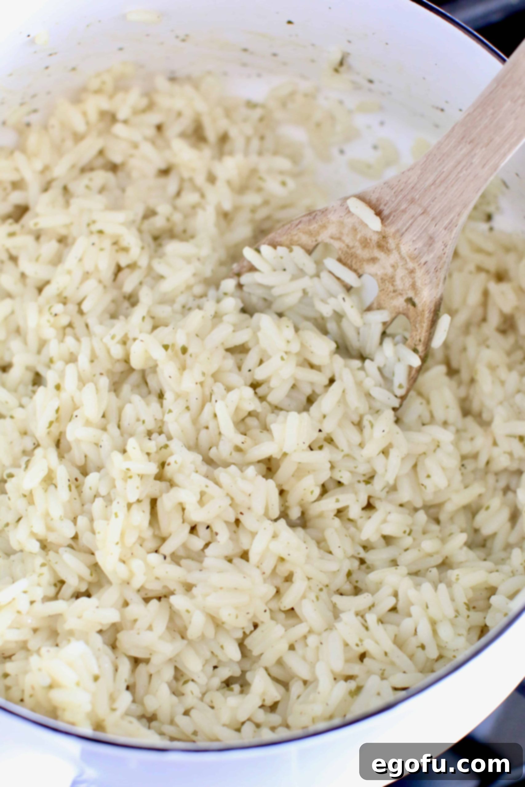 Zatarain's Cilantro Lime Rice, prepared in a white sauce pan with a wooden spoon.