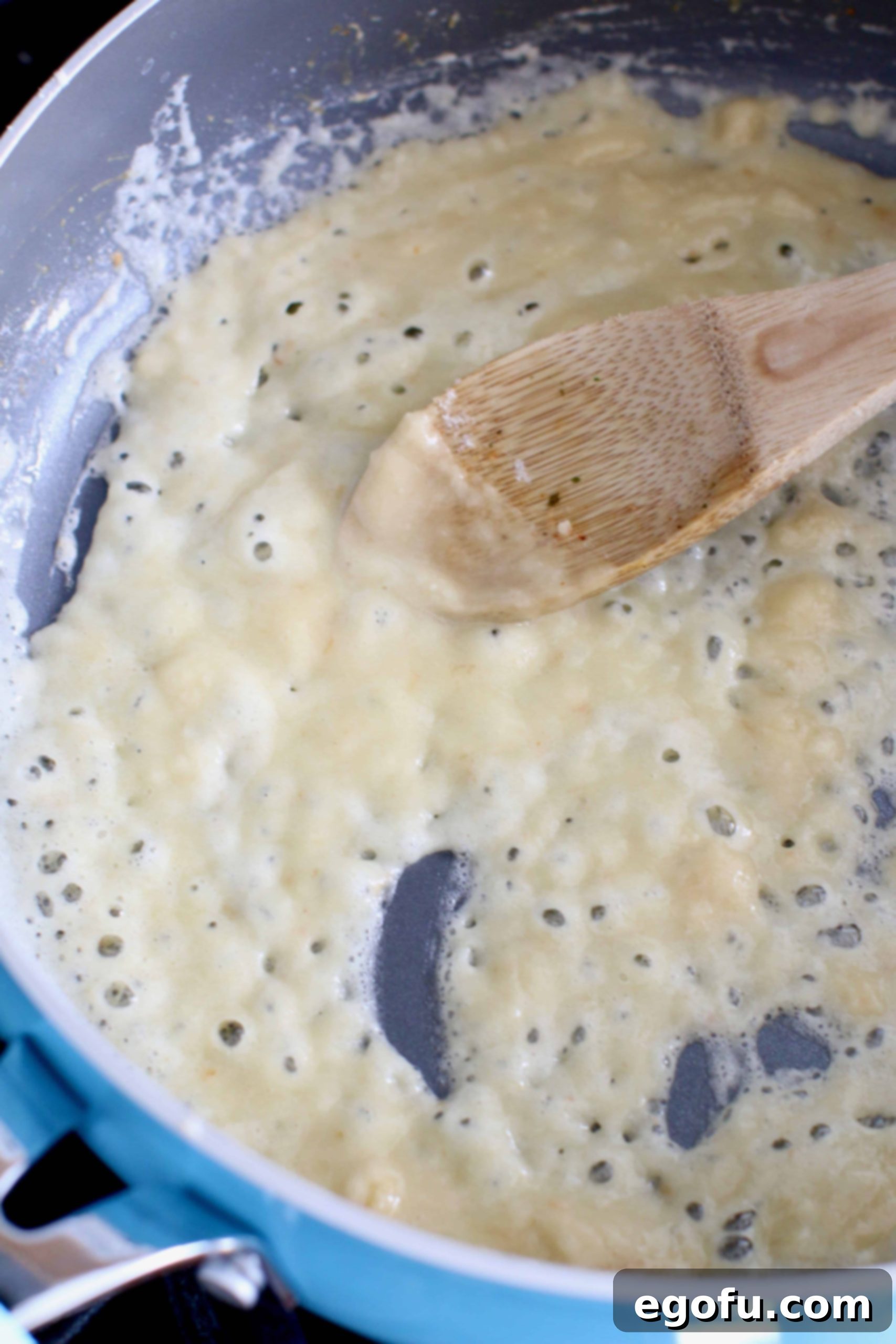 making a roux in a large skillet with a wooden spoon.