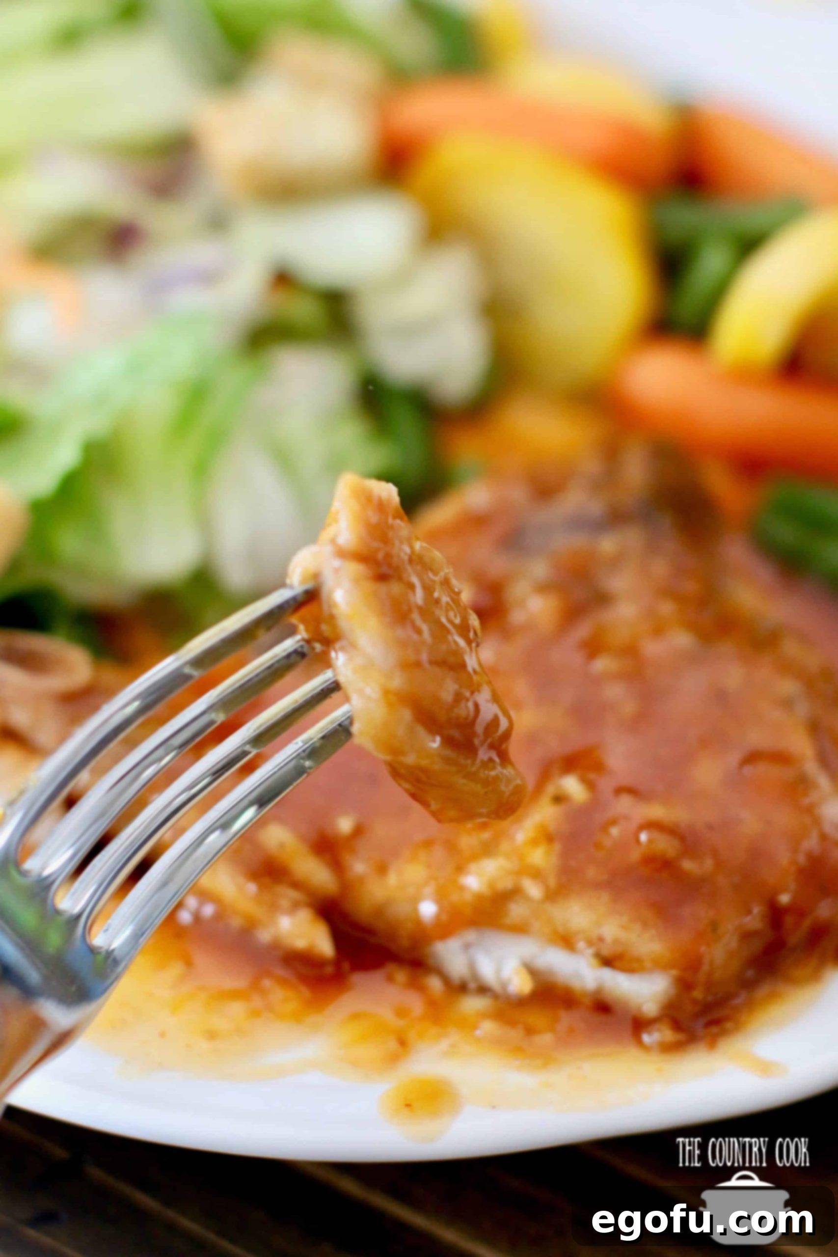Slow Cooker Barbecue Pork Chops, sliced, slice shown on a fork.