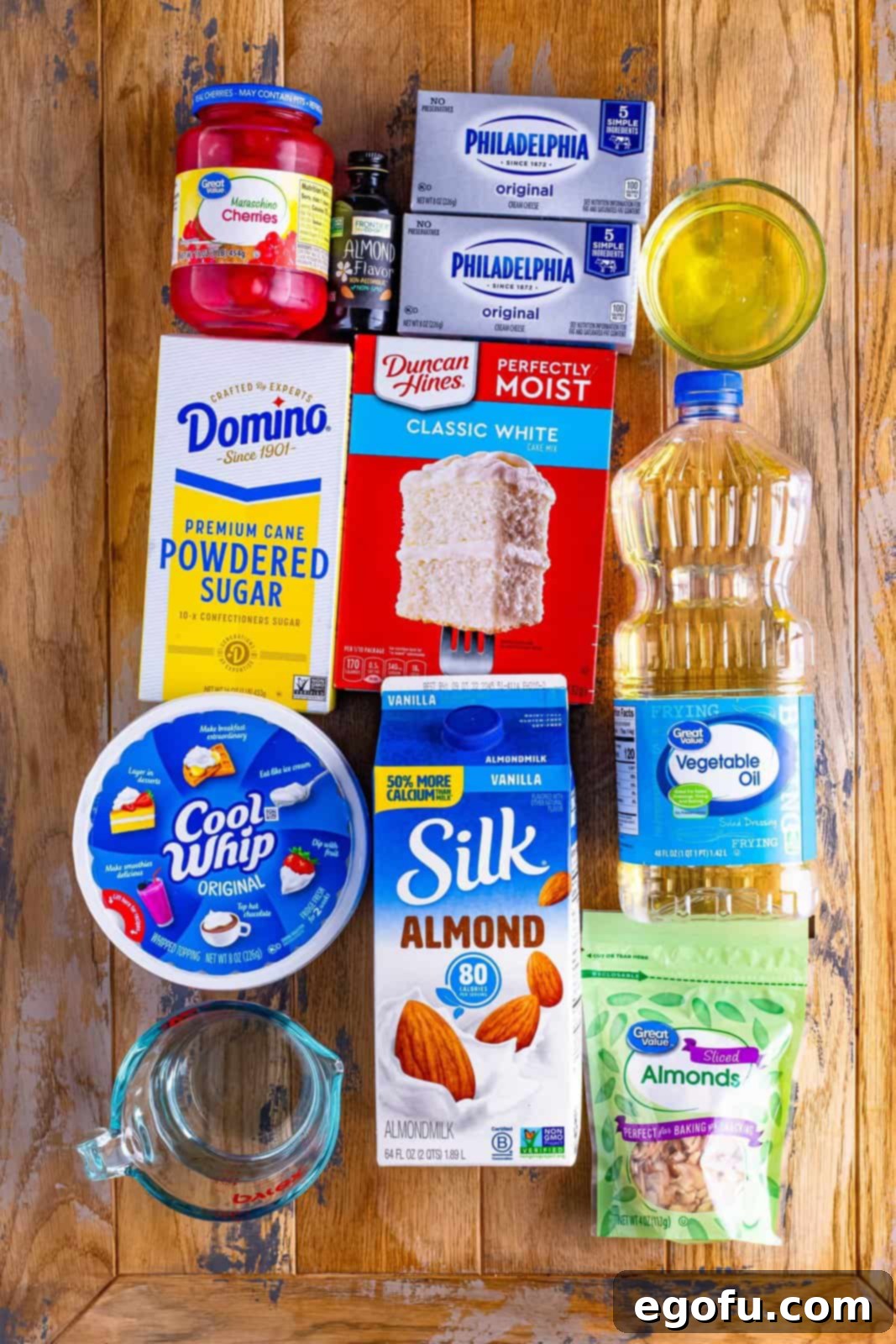 white cake mix, powdered sugar, Cool Whip, maraschino cherries, almond extract, slivered almonds, egg whites, oil and water and almond milk.