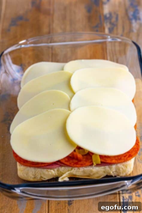 Layered Slider sandwiches in a casserole dish.