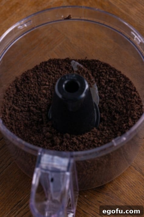 Melted butter added to Oreo cookie crumbs in a food processor.
