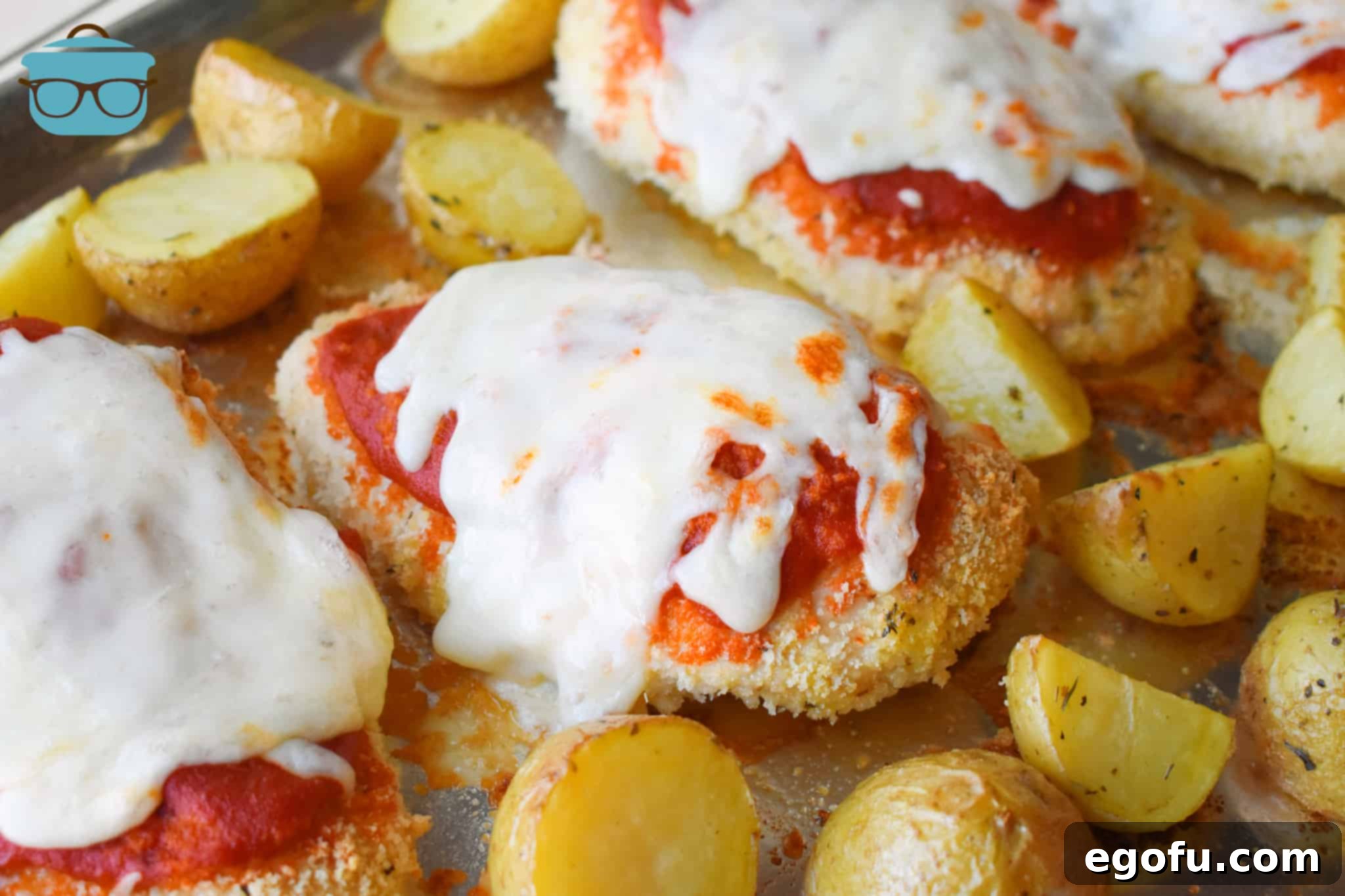 Sheet Pan Chicken Parmesan and Potatoes on aluminum foil covered baking sheet.