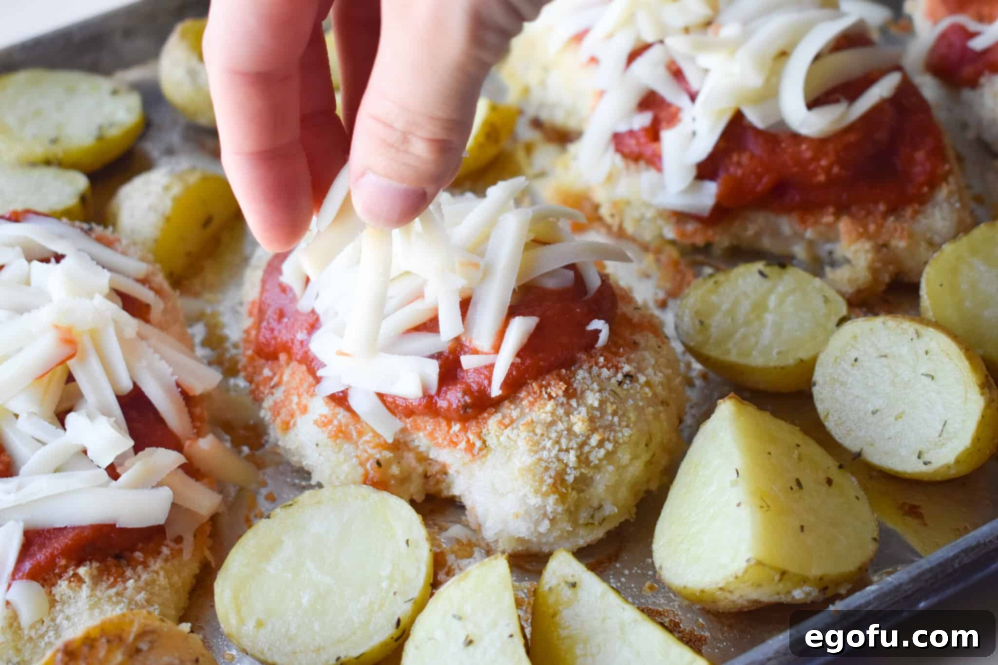 sprinkling shredded mozzarella on baked chicken breasts.