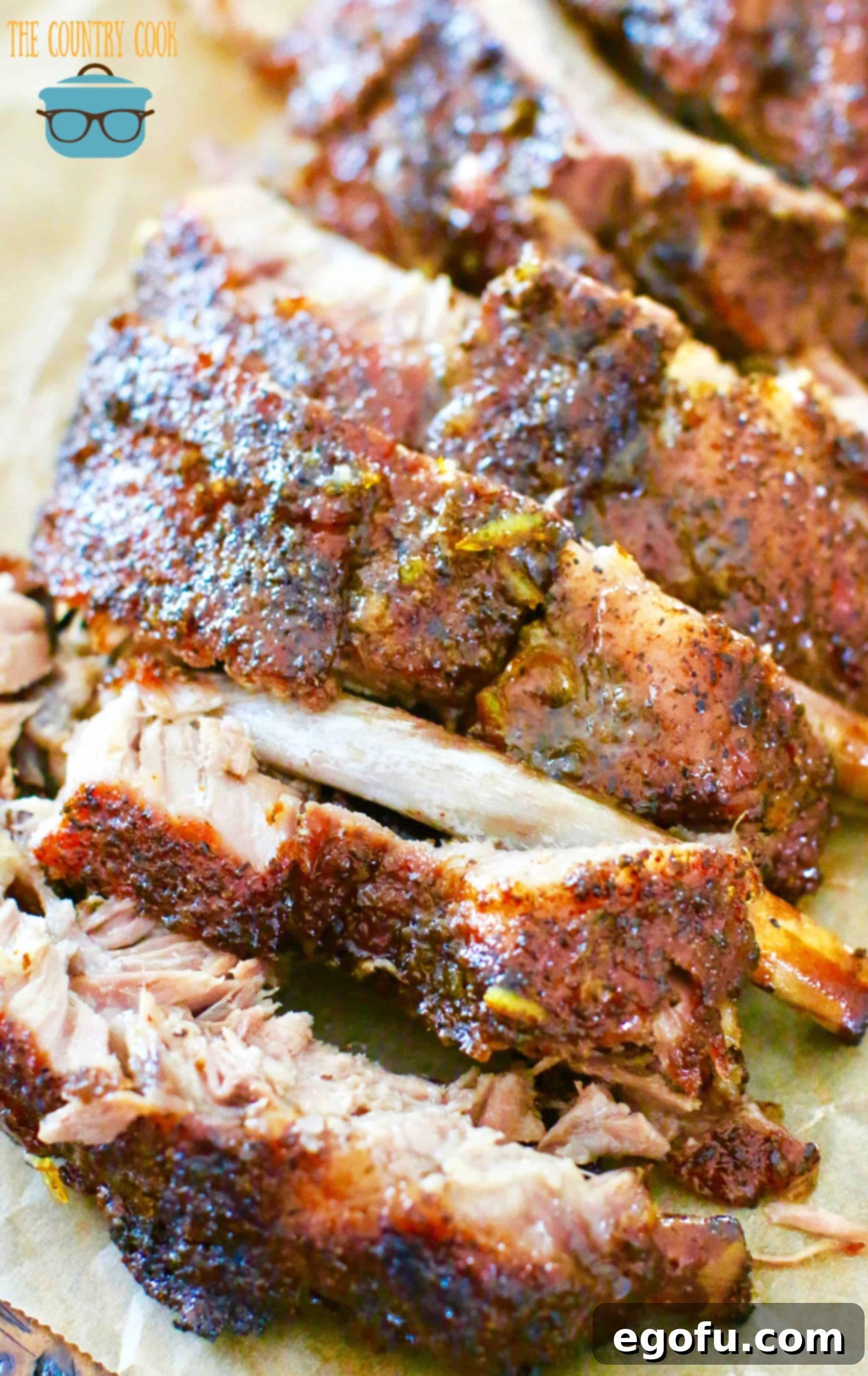 Perfectly sliced grilled pork ribs arranged on brown parchment paper, showcasing their tenderness and juicy interior.