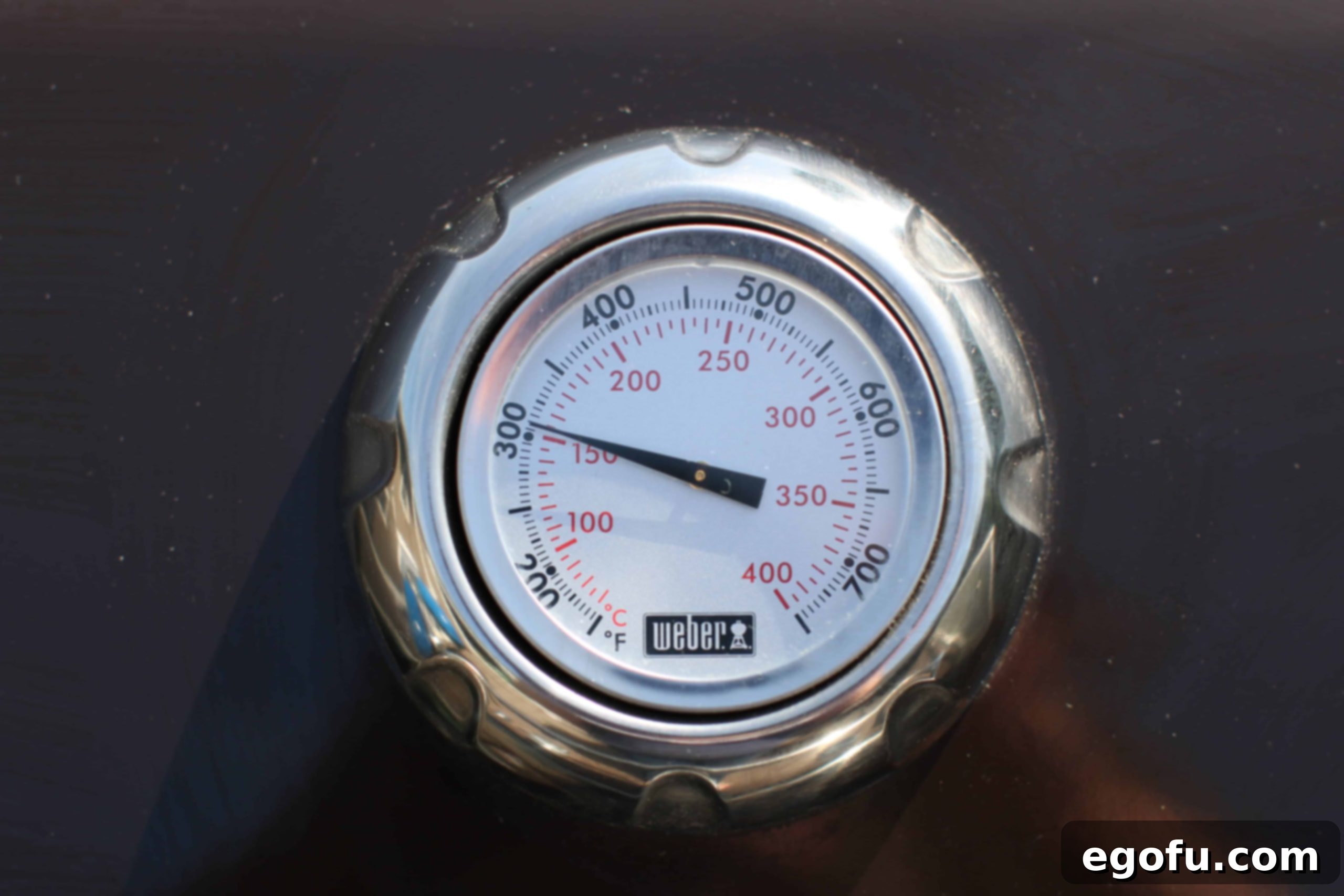 A gas grill preheating to 300°F, showing the thermometer gauge, indicating readiness for cooking ribs.