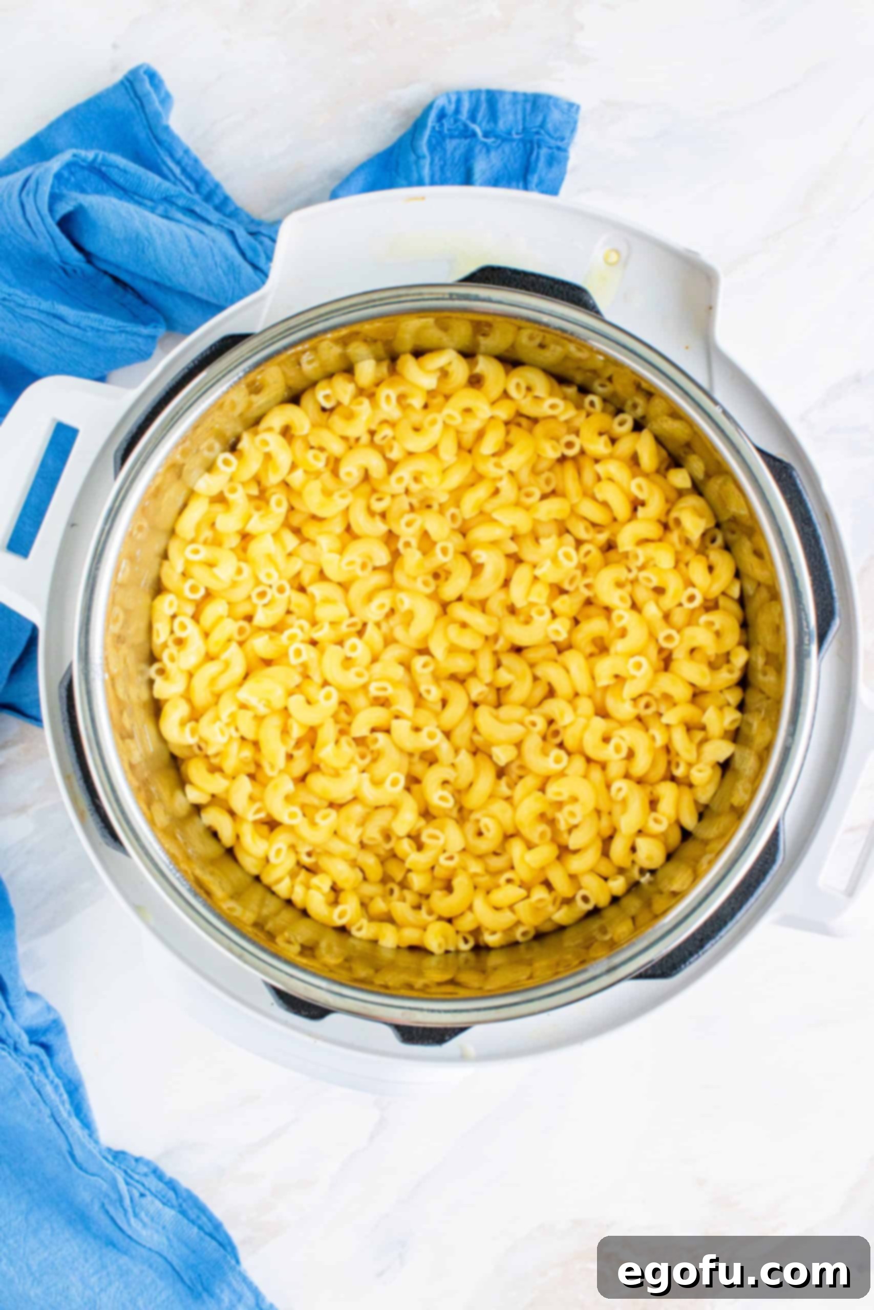 Perfectly cooked macaroni noodles in the bottom of the Instant Pot insert, ready for the cheese sauce.
