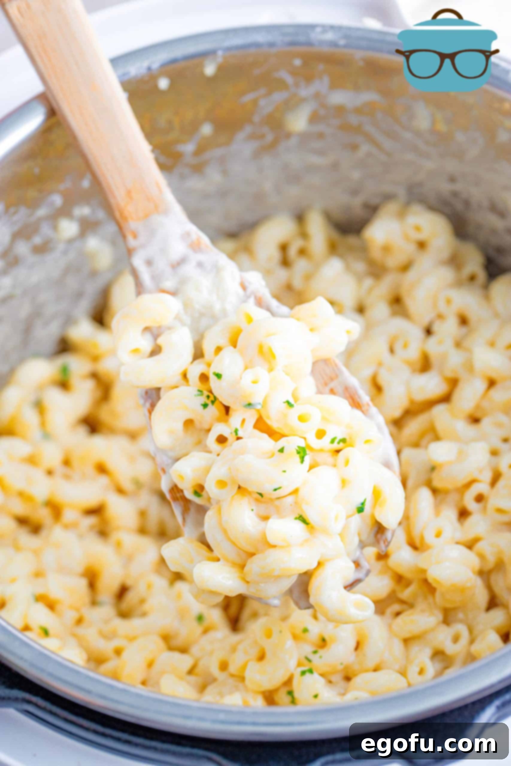 A wooden spoonful of creamy macaroni and cheese, ready to be enjoyed.