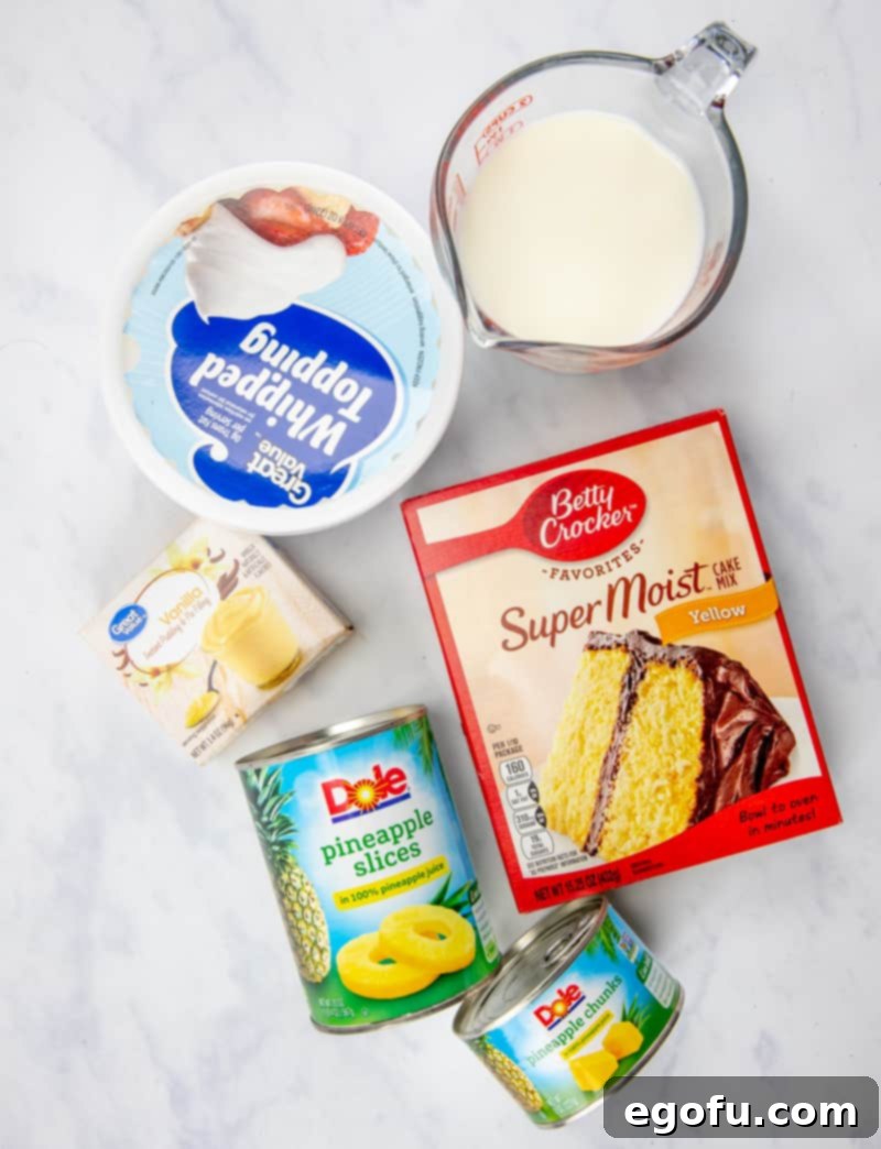 A flat lay photograph showcasing all the ingredients for Pineapple Pudding Poke Cake: pineapple slices, yellow cake mix, eggs, oil and water, instant vanilla pudding mix, milk, whipped topping (Cool Whip), and pineapple chunks.